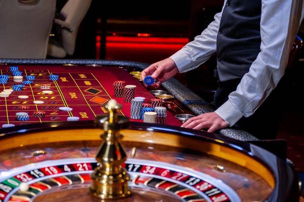 Croupier,Behind,Gambling,Table,In,A,Casino.,Roulette,Wheel,And