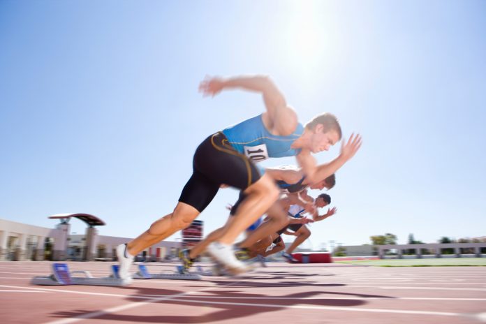 Side,View,Of,Young,Male,Sprinters,Leaving,Their,Starting,Blocks