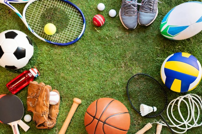 Various,Sports,Equipment,On,Grass,,Including,A,Soccer,Ball,,Tennis